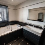 La salle de bain avec douche et baignoire balnéo