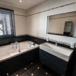 La salle de bain avec douche et baignoire balnéo
